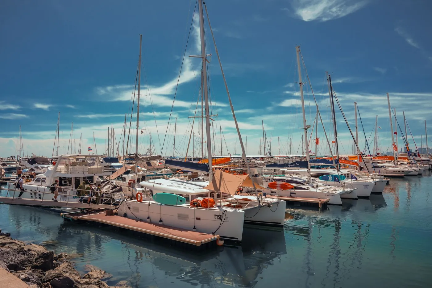 Yachts and catamarans in a Thai marina, a city skyline on the horizon