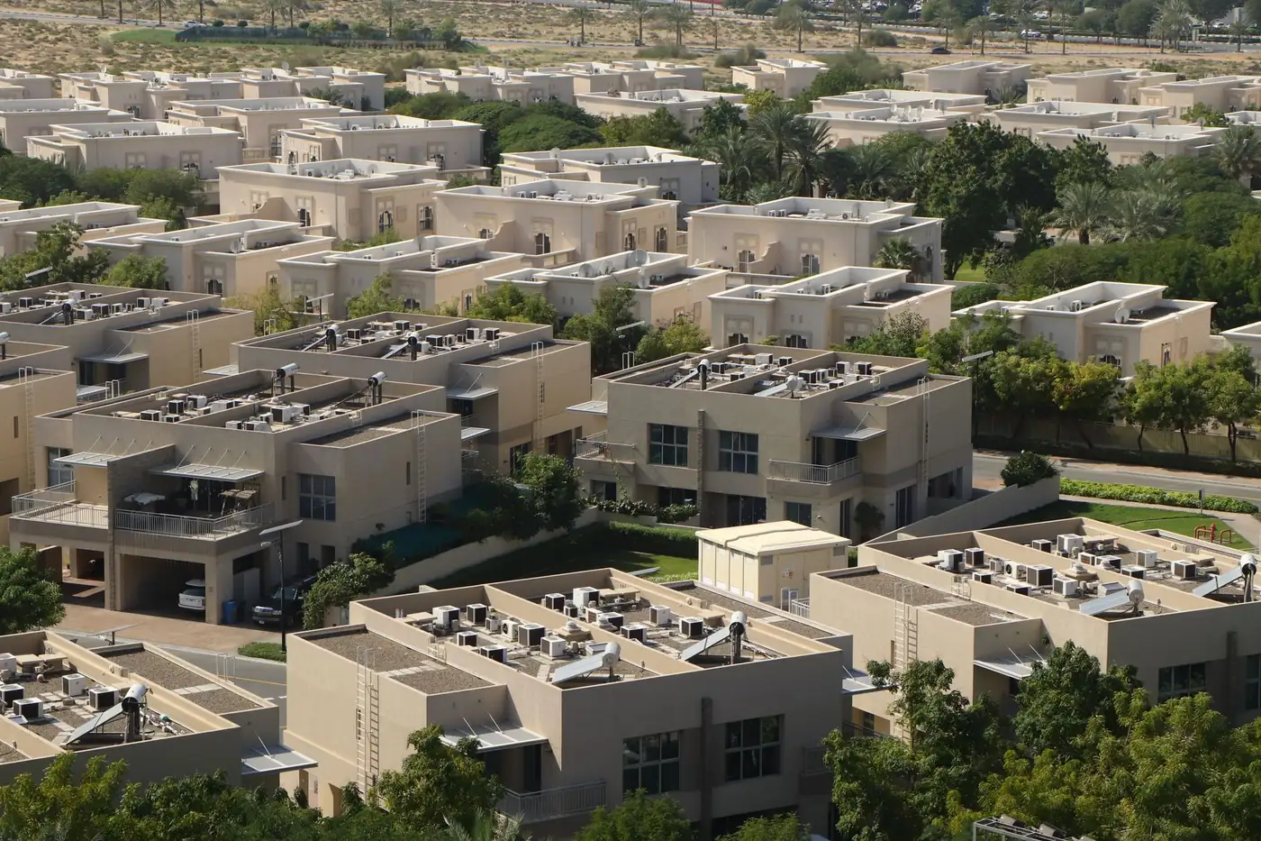 A low-rise villa community with mature planting between the streets