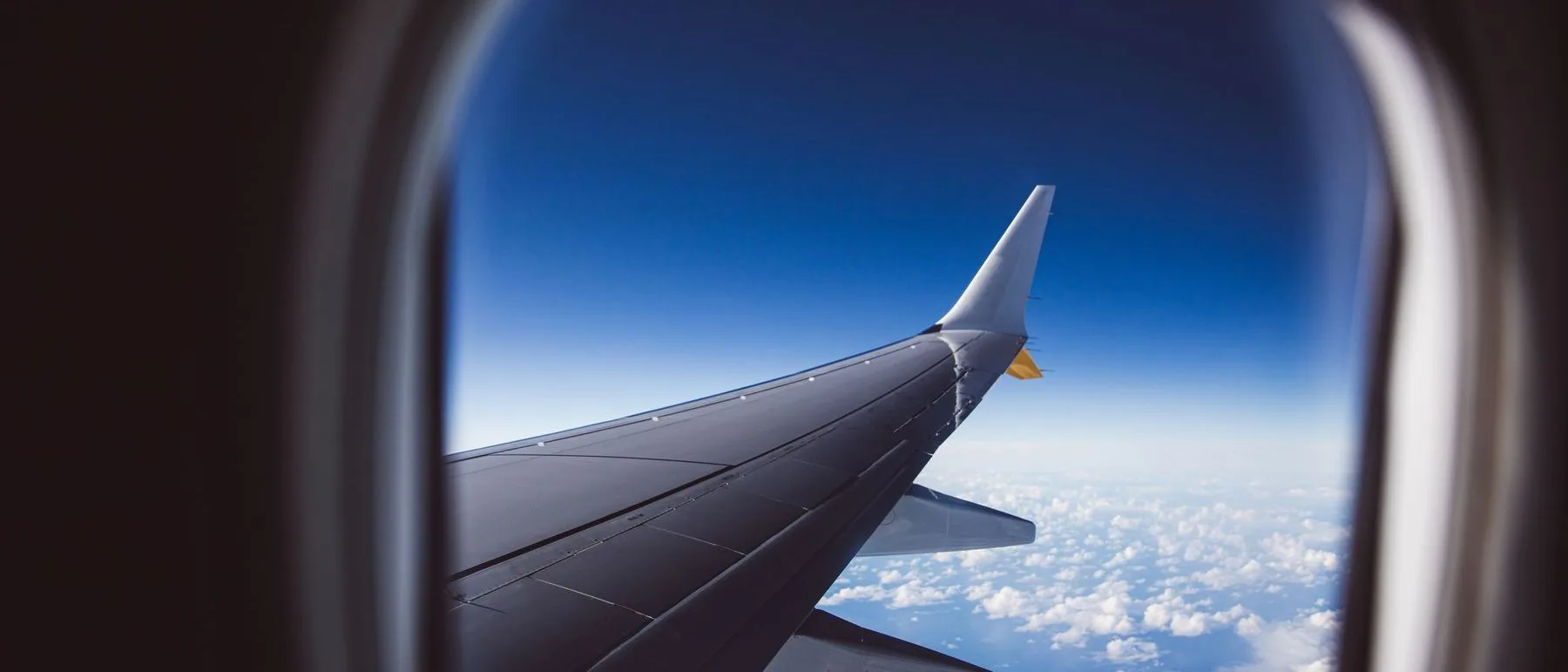 Aircraft wing above a cloud layer in daylight