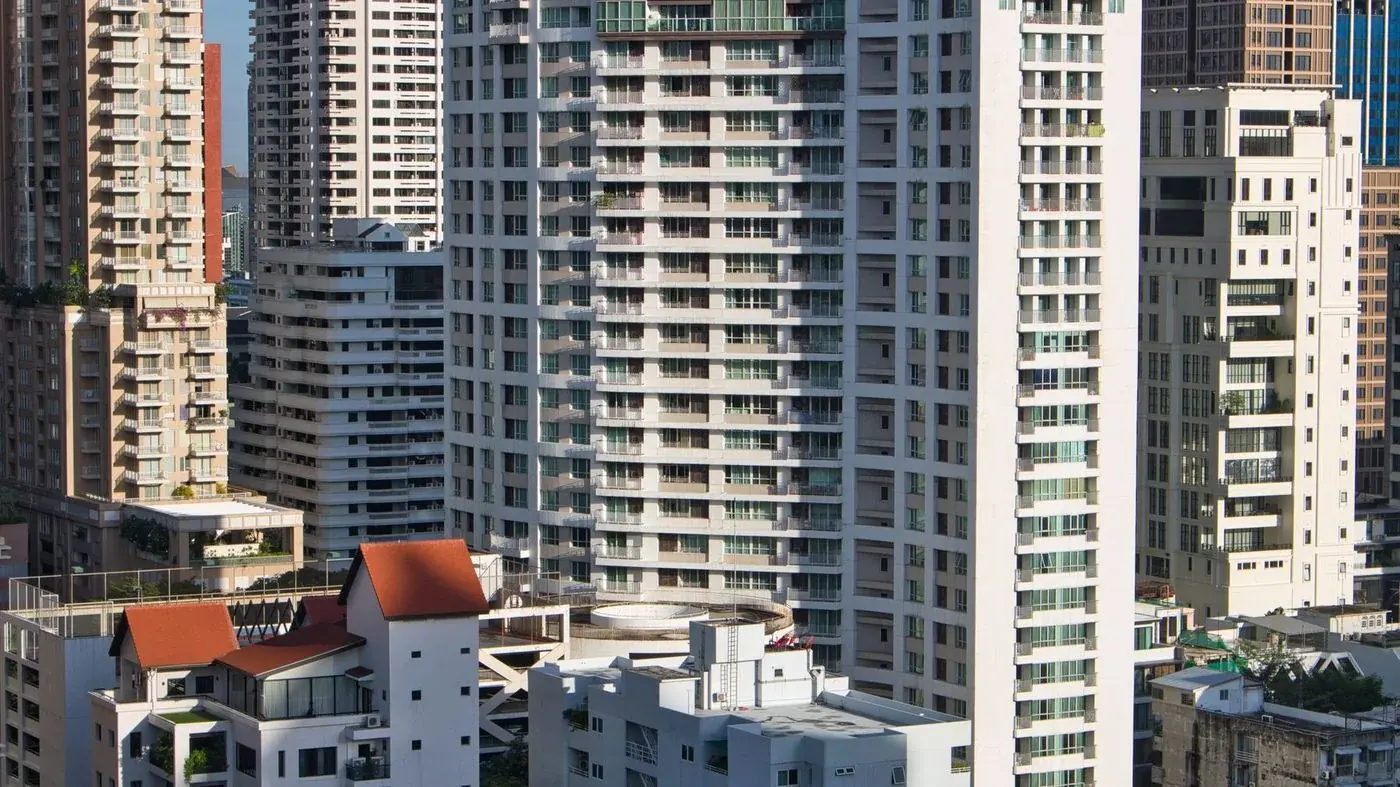 Balcony of a Thai condominium looking out over greenery and the coastline