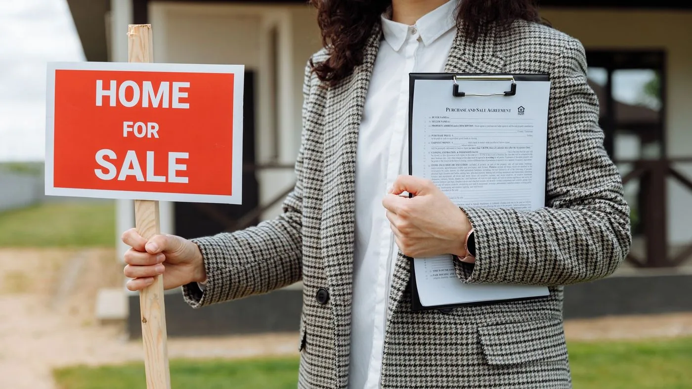 Two people signing a property contract at a table