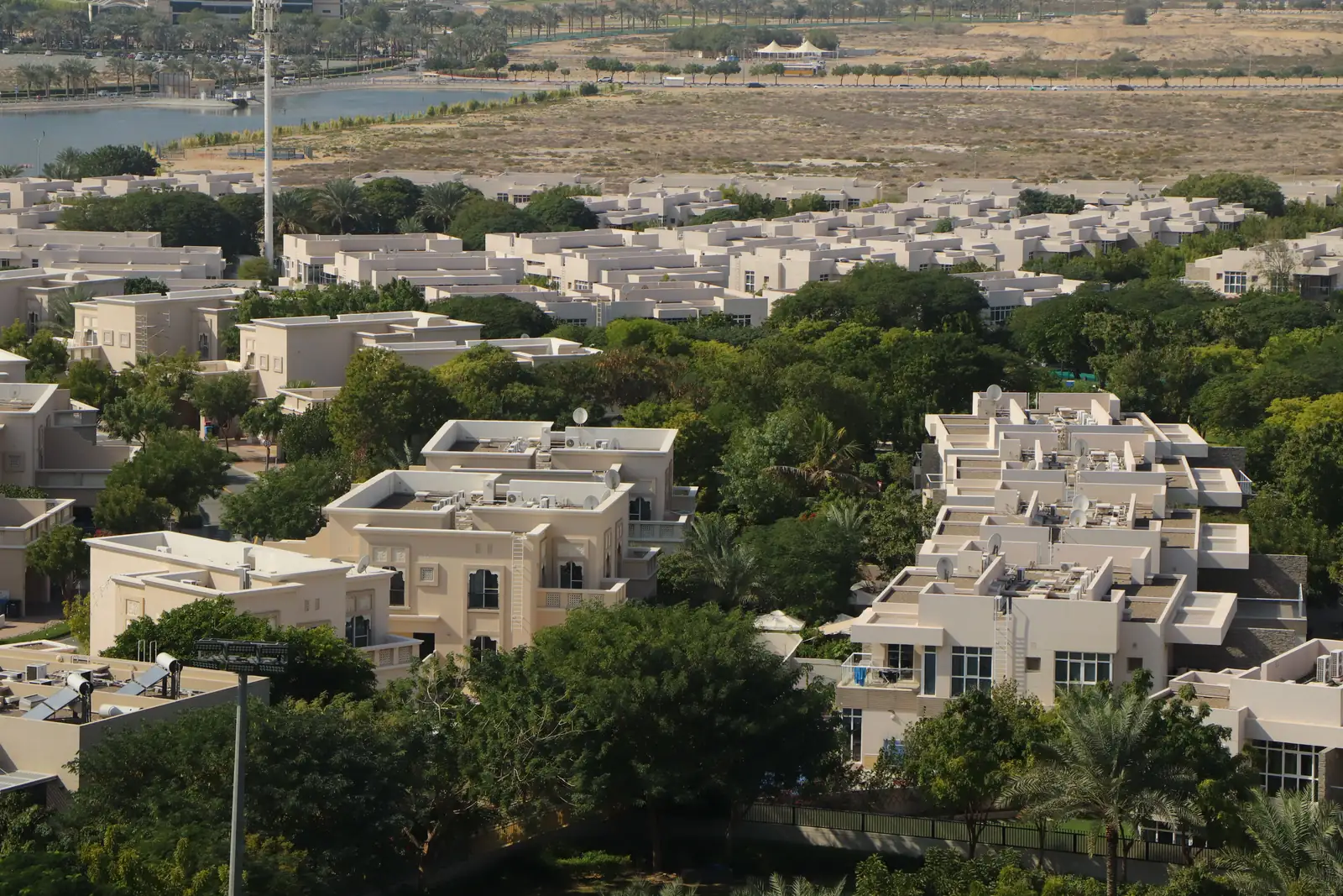 A low-rise villa community, landscaped streets and the desert beyond it